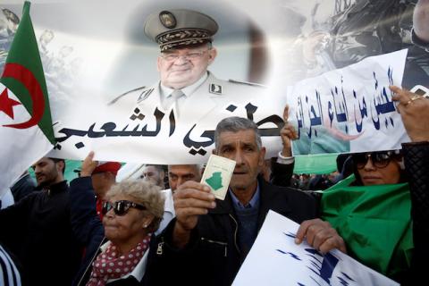 Pro-government supporters carry a banner depicting Army Chief of Staff Lieutenant General Ahmed Gaed Salah during a demonstration rejecting foreign interference and in favour of a coming presidential election in Algiers, Algeria, on November 30, 2019. PHOTO BY REUTERS/Ramzi Boudina