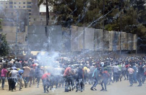 Supporters of Egypt's former president Mohamed Mursi run from tear gas during clashes with police in Cairo,