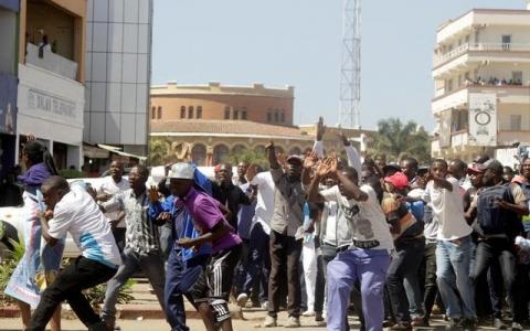 Supporters of Democratic Republic of Congo's opposition Presidential candidate Moise Katumbi shield him as riot police fire teargas at them as they escort him to the prosecutor's office over government allegations he hired mercenaries in a plot against the state, in Lubumbashi, the capital of Katanga province of the Democratic Republic of Congo, May 13, 2016. PHOTO BY REUTERS/Kenny Katombe