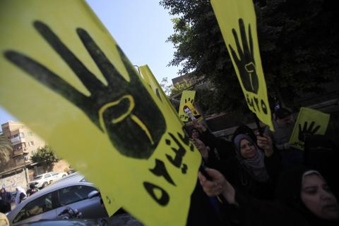 Supporters of the Muslim Brotherhood and ousted Egyptian President Mohamed Mursi shout slogans against the military and interior ministry while holding his poster and gesturing with four fingers in front of Al Rayyan mosque after Friday prayer