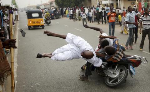 Supporters of the presidential candidate Muhammadu Buhari and his All Progressive Congress hits another supporter with a motorbike during celebrations in Kano, March 31, 2015. PHOTO BY REUTERS/Goran Tomasevic