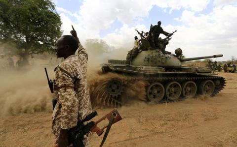 A military personnel gestures next to a tank after the Sudanese Armed Forces (SAF) and the Rapid Support Forces (RSF) recaptured the Daldako area, outside the military headquarters in Kadogli, May 20, 2014. PHOTO BY REUTERS/Mohamed Nureldin Abdallah