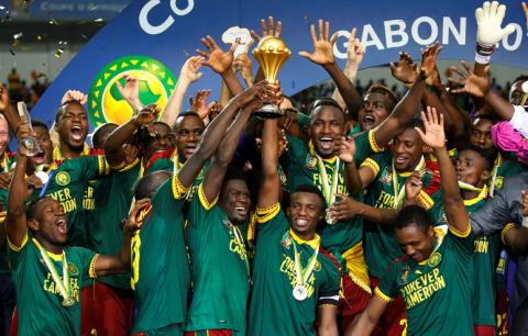 Cameroon's Benjamin Moukandjo celebrates with the trophy and team mates after winning the African Cup of Nations. PHOTO BY REUTERS/Mike Hutchings Livepic