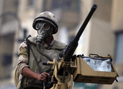 A soldier rides on an armoured personnel carrier (APC) at Tahrir Square after clashes with pro-Mursi protesters in Cairo