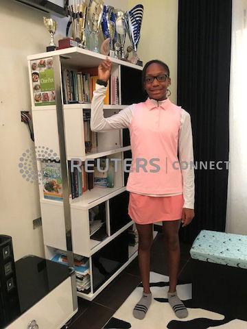 Iyeneobong Essien,13-year-old golf prodigy points at her trophies as she poses for a photograph at home in Abuja, Nigeria, October 27, 2019. PHOTO BY REUTERS/Abraham Achirga