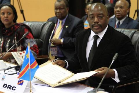 The Democratic Republic of Congo's President Joseph Kabila signs the Kampala communique during the extraordinary summit of the International Conference on the Great Lakes Region