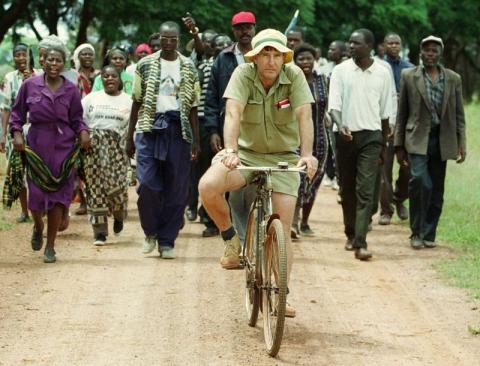 Zimbabwean commercial famer Tommy Bayley rides an old bicycle ahead of war veterans and villagers, who invaded his farm Danbury Park 30 Km's north west of Harare April 8, to an abondoned house to use as temporary shelter. PHOTO BY REUTERS