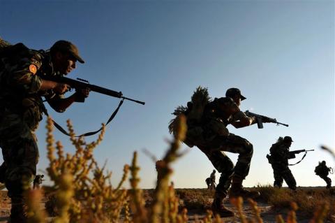 Trainee soldiers from the Libyan army execute combat manoeuvres during their graduation exam in Geminis