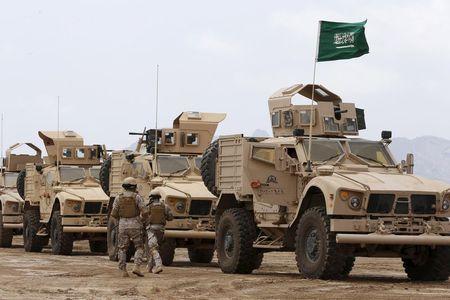 Saudi troops walk past armoured personnel carriers at their base in Yemen's southern port city of Aden, September 28, 2015. PHOTO BY REUTERS/Faisal Al Nasser