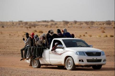 Migrants crossing the Sahara desert into Libya ride on the back of a pickup truck outside Agadez, Niger, May 9, 2016. PHOTO BY REUTERS/Joe Penney