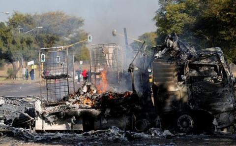 Locals walk past a shell of a burnt out truck used to barricade roads by protesters in Atteridgeville a township located to the west of Pretoria, South Africa, June 21, 2016. PHOTO BY REUTERS/Siphiwe Sibeko