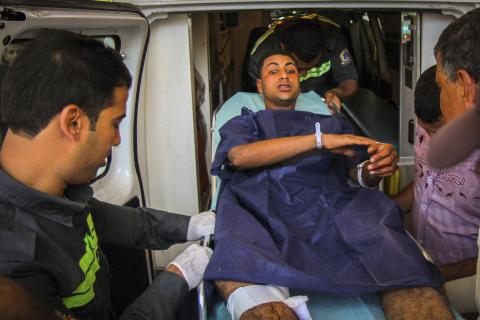 Members of the Egyptian Civil Protection Authority lift an injured man who was wounded during a bomb attack targeting a traffic security post near a courthouse in Cairo's Heliopolis district