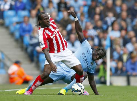 Manchester City's Bacary Sagna (R) challenges Stoke City's Victor Moses during their English Premier League soccer match at the Etihad stadium in Manchester, northern England