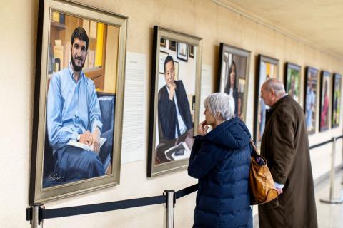 Visitors examine Artist Betsy Ashton's exhibition, "Portraits of Immigrants: Unknown Faces, Untold Stories" at Riverside Church in New York, U.S., March 10, 2019. PHOTO BY REUTERS/Demetrius Freeman