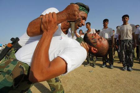 Shiite volunteers, who have joined the Iraqi army to fight against the predominantly Sunni militants from the radical Islamic State of Iraq and the Levant (ISIL), demonstrate their skills during a graduation ceremony after completing their field training in Najaf, June 27, 2014. PHOTO BY REUTERS/Alaa Al-Marjani