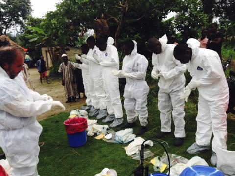 Volunteers prepare to remove the bodies of people who were suspected of contracting Ebola and died in the community in the village of Pendebu, north of Kenema