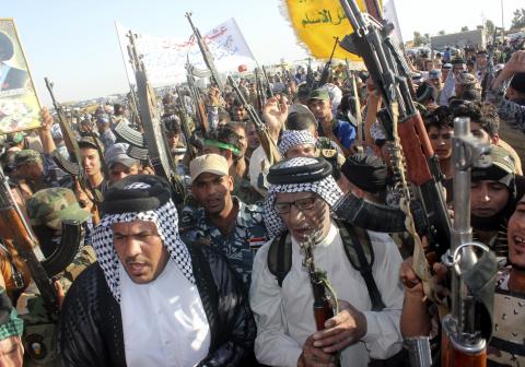 Shi'ite volunteers, who have joined the Iraqi army to fight against the predominantly Sunni militants from the radical Islamic State of Iraq and the Levant (ISIL), take part in a parade on a street in Kanaan, Diyala province