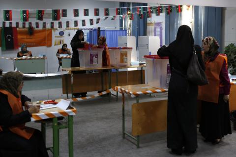 A woman votes at a polling station inside a school in Tripoli