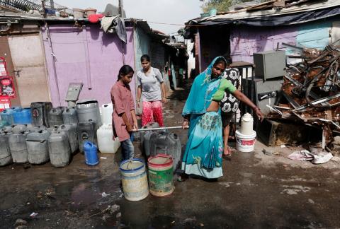 A woman and her daughter carry a container after filling it with drinking water from a municipal tanker in New Delhi, India, June 28, 2019. PHOTO BY REUTERS/Adnan Abidi