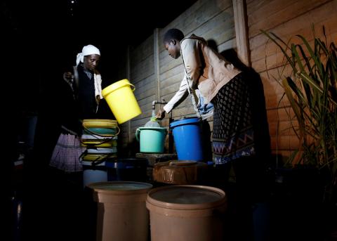 Residents collect water at night from an electric-powered borehole, as the country faces 18-hour daily power cuts, in a suburb of Harare, Zimbabwe, July 30, 2019. PHOTO BY REUTERS/Philimon Bulawayo