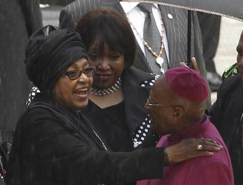 Winnie Mandela (L), ex-wife of former South African President Nelson Mandela, chats with former Archbishop Desmond Tutu during the national memorial service for Nelson Mandela at the First National Bank (FNB) Stadium