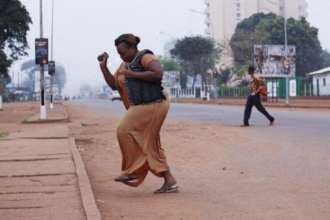 A woman runs from gunfire in Bangui