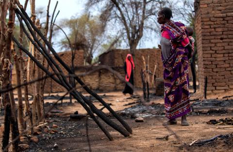 A woman looks at burnt houses during clashes between nomads and residents in Deleij village, located in Wadi Salih locality, Central Darfur, Sudan, June 11, 2019. PHOTO BY REUTERS/Stringer