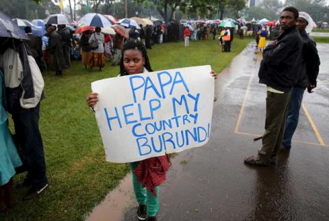 A woman holds a banner written "Papa Help My Country Burundi" in a file photo. PHOTO BY REUTERS/Goran Tomasevic