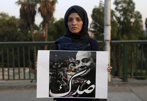 A woman carries a poster of presidential candidate and former army chief Abdel Fattah al-Sisi, with the slogan "Against you", during a protest on the 6th October bridge near Tahrir square in Cairo