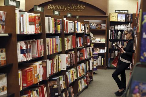 A woman reads a book at a Barnes & Noble bookstore in Pasadena, California November 26, 2013. Barnes & Noble Inc, the largest U.S. bookstore chain, on Tuesday reported a higher than expected quarterly profit as it cut store workers' hours scaled back its money losing Nook business, helping it offset sharp sales declines. PHOTO BY REUTERS/Mario Anzuoni