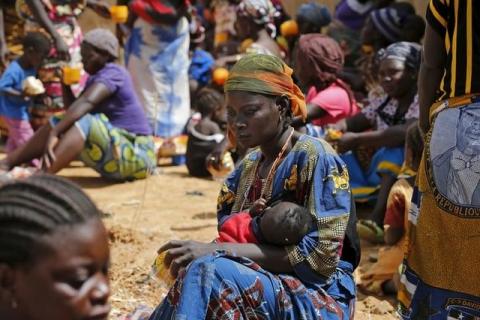 A woman reflects while feeding her baby at a registration centre in Geidam stadium, Nigeria May 6, 2015. PHOTO BY REUTERS/Afolabi Sotunde