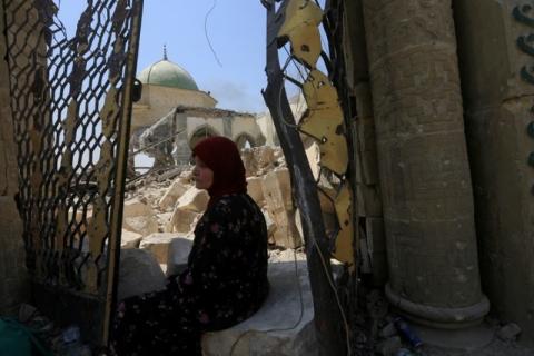 A displaced woman sits near the ruined Grand al-Nuri Mosque in the Old City of Mosul, Iraq, July 1, 2017. PHOTO BY REUTERS/Alaa Al-Marjani