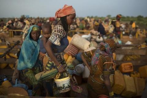 Women carry their belongings as they disembark from trucks carrying internally displaced muslims, after travelling in convoy escorted by the African Union operation in CAR (MISCA) on a four-day journey from the capital Bangui, at the transit IDP centre in the outskirts of the Central African Republic-Chad border town of Sido, April 30, 2014. PHOTO BY REUTERS/Siegfried Modola