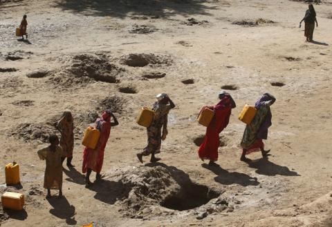 Women carry jerry cans of water from shallow wells dug from the sand along the Shabelle River bed, which is dry due to drought in Somalia's Shabelle region, March 19, 2016. PHOTO BY REUTERS/Feisal Omar