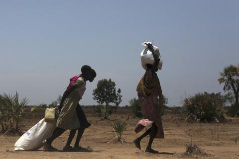 Women carry food at a food distribution site in Nyal, Unity State