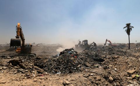 Municipal workers drive shovel machines to extinguish fires inside the garbage at a rubbish dump in Baghdad, Iraq, May 30, 2019. PHOTO BY REUTERS/Thaier al-Sudani