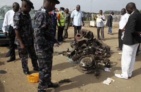 Air Commodore Charles Otegbade (3rd L), director of search and rescue operations, looks at the wreckage after a bomb blast at Nyayan bus terminal in Abuja