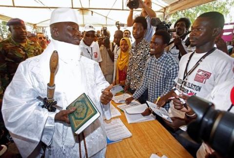 Gambia's Yahya Jammeh holds a copy of the Quran while speaking to a poll worker at a polling station during the presidential election in Banjul, Gambia, December 1, 2016. PHOTO BY REUTERS/Thierry Gouegnon