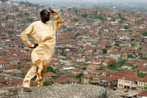 Yinka Sotomi stands atop Oluma Rock, a spiritual site for the Yoruba tribe, overlooking the city of Abeokuta in southern Nigeria, April 16, 2007. PHOTO BY REUTERS/Finbarr O'Reilly