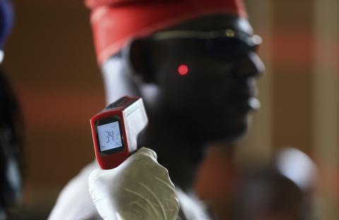 A man has his temperature taken using an infrared digital laser thermometer at the Nnamdi Azikiwe International Airport in Abuja