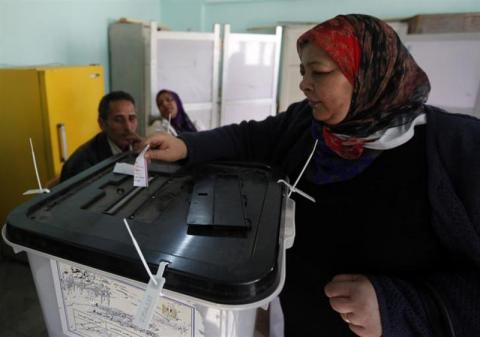 Women cast their votes at a polling centre during a referendum on Egypt's new constitution in Cairo