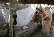 Hadija Sahik, a 48-year-old woman, sets up her new mosquito net in a file photo. PHOTO BY REUTERS/Wolfgang Rattay