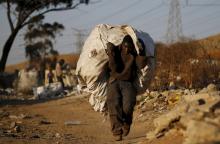 An unemployed man carries a bag full of recyclable waste material which he sells for a living, in Daveland near Soweto, South Africa, August 4, 2015. PHOTO BY REUTERS/Siphiwe Sibeko