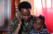 Henok Asgedom, an Eritrean refugee uses his mobile phone to talk to his mother in Eritrea as he holds his son Nebiyu Henok 2 in his apartment in Addis Ababa, Ethiopia, July 12, 2018. PHOTO BY REUTERS/Tiksa Negeri