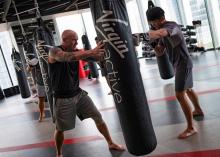 A trainer guides a gym member punching a sandbag at Virgin Active fitness club in central Singapore, March 5, 2019. PHOTO BY REUTERS/Loriene Perera