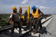 Men work on a train track at the National Arts Theatre stop of the light rail system under construction in Lagos, Nigeria, May 30, 2014. PHOTO BY REUTERS/Joe Penney