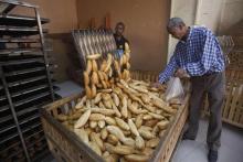 A customer inspects freshly-baked bread in a bakery in Tripoli