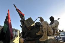 A member of the Libyan army's Thunderbolt Brigade sits at the back of a vehicle as the army prepares for deployment in Benghazi