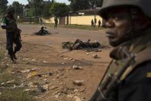 African Union (AU) peacekeeping soldiers stand near burnt bodies of two Muslim men who were killed by a crowd in a street of the capital Bangui