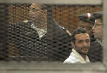 Political activist Ahmed Douma of the 6 April movement looks on behind bars in Cairo